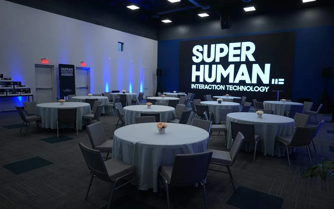 The main hall set with round dinner tables under the LED wall