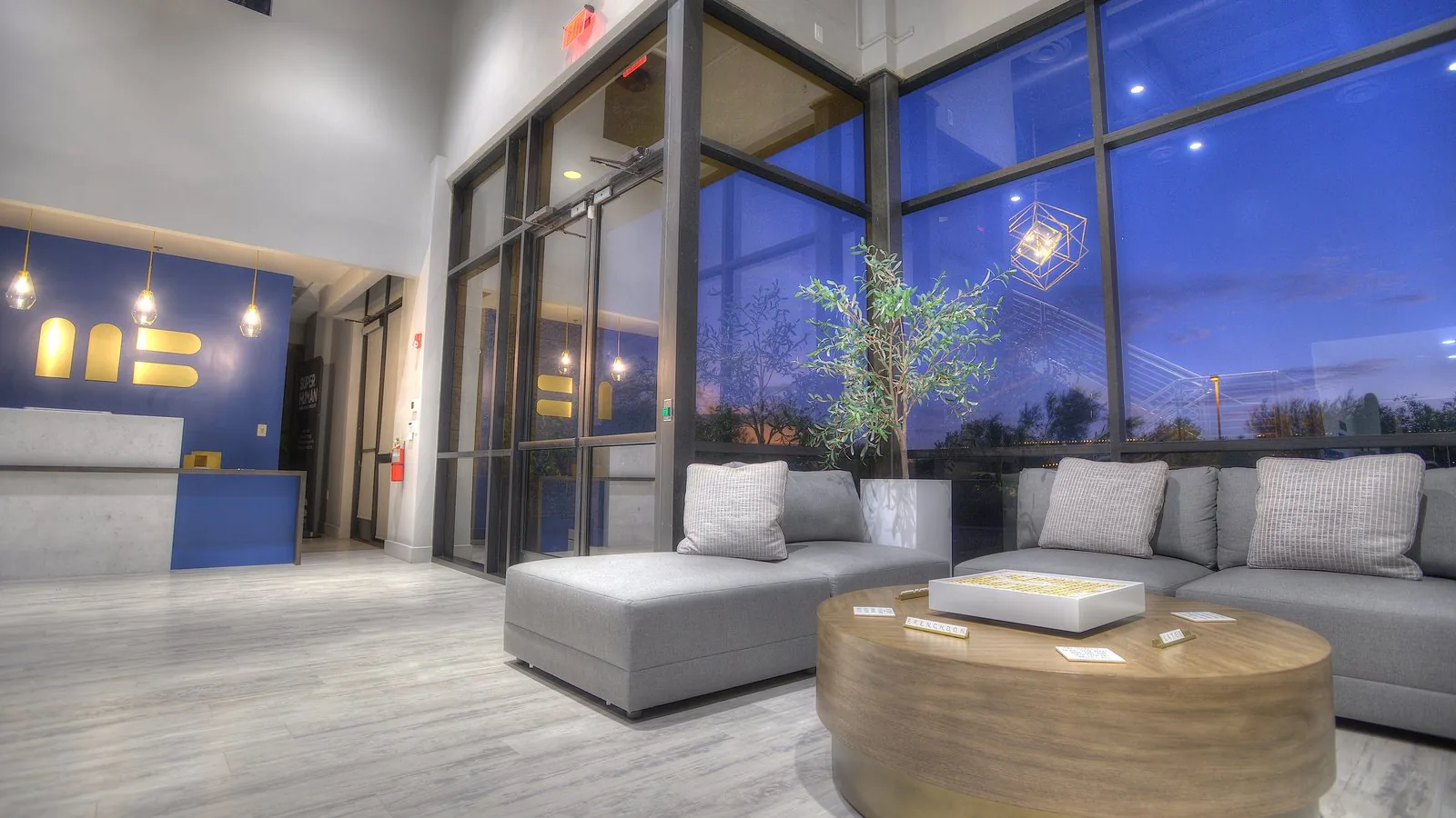 The lobby lounge with floor-to-ceiling windows and the gold MB monogram at reception