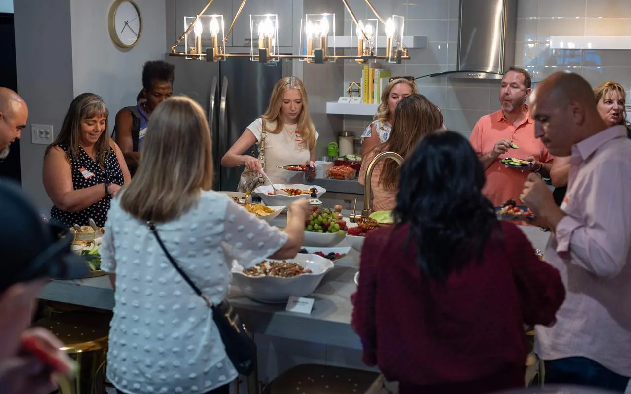 Attendees gathered around the kitchen island during a break